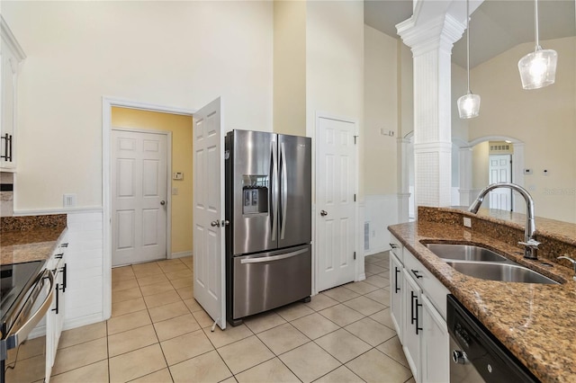 kitchen with a sink, light tile patterned floors, ornate columns, and stainless steel appliances