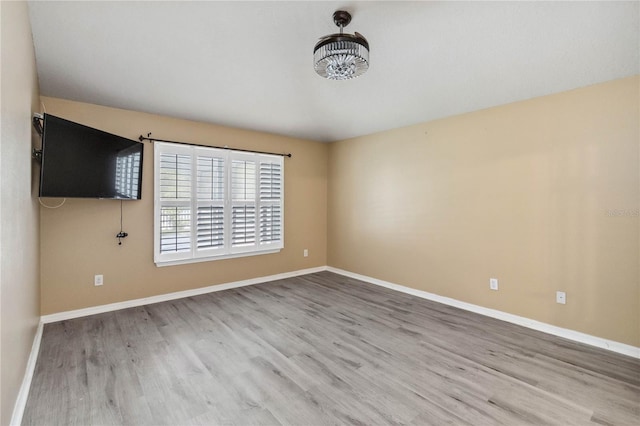 empty room with baseboards and wood finished floors