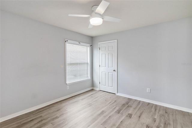 empty room featuring light wood-style flooring, a ceiling fan, and baseboards