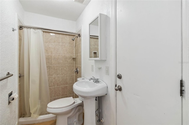 full bath with toilet and a stall shower