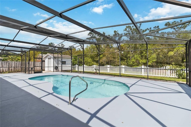 view of pool featuring a lanai, an outdoor structure, and a fenced backyard