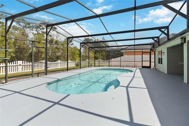 view of pool with glass enclosure, a patio area, a fenced backyard, and a fenced in pool