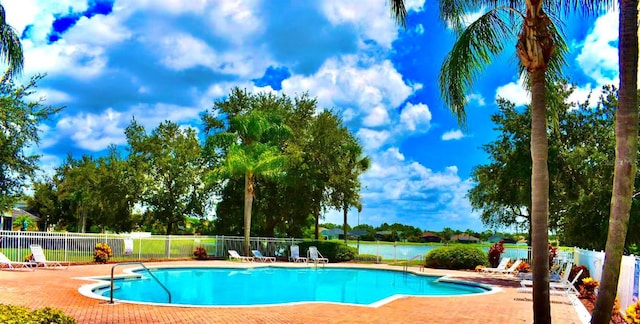 pool with a patio area and fence