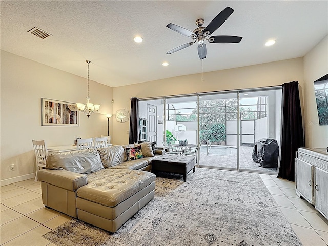 living area with light tile patterned floors, visible vents, lofted ceiling, a textured ceiling, and ceiling fan with notable chandelier