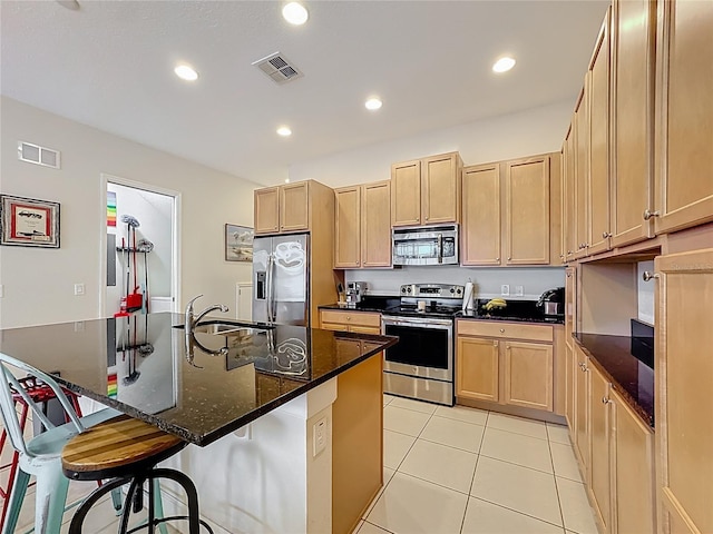 kitchen featuring light tile patterned flooring, visible vents, appliances with stainless steel finishes, and light brown cabinetry