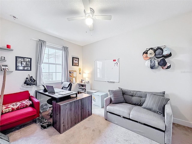 office area featuring light carpet, a textured ceiling, baseboards, and ceiling fan