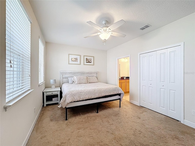 bedroom featuring visible vents, ceiling fan, baseboards, light carpet, and a textured ceiling