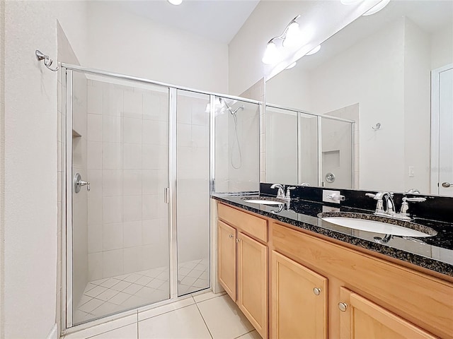 full bath featuring tile patterned floors, a shower stall, and a sink