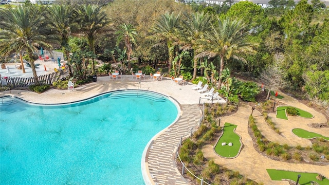 community pool with a patio area and fence