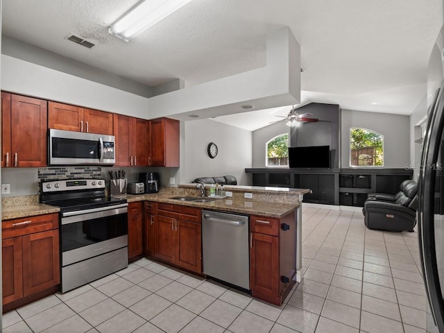 kitchen featuring a sink, stainless steel appliances, a peninsula, and open floor plan