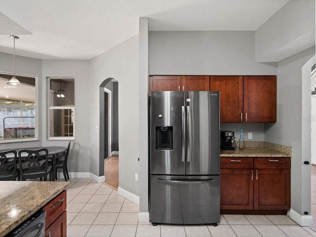 kitchen featuring light stone countertops, light tile patterned flooring, arched walkways, stainless steel appliances, and pendant lighting