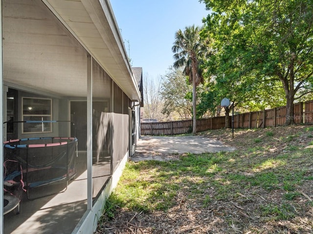 view of yard featuring a patio, fence, and a sunroom