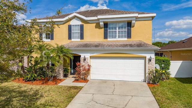 traditional-style home with stucco siding, a garage, driveway, and fence