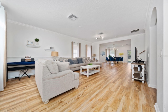 living area featuring a notable chandelier, visible vents, and light wood-style flooring