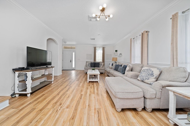 living room featuring an inviting chandelier, wood finished floors, and ornamental molding