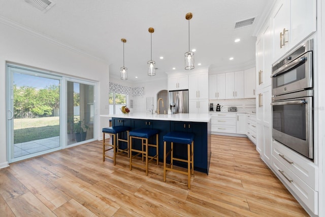 kitchen with decorative backsplash, visible vents, light wood finished floors, and stainless steel appliances