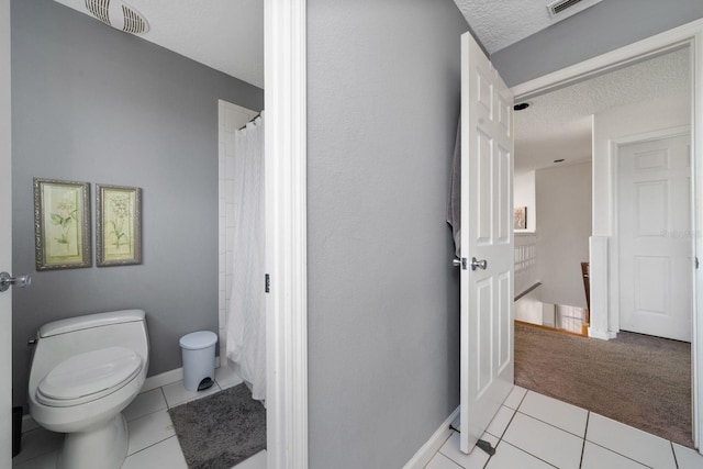 full bath with tile patterned floors, visible vents, a textured ceiling, and toilet