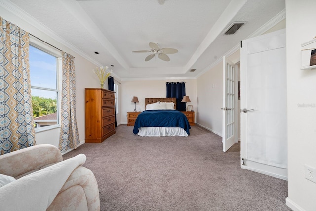 bedroom featuring carpet, visible vents, baseboards, a tray ceiling, and ceiling fan