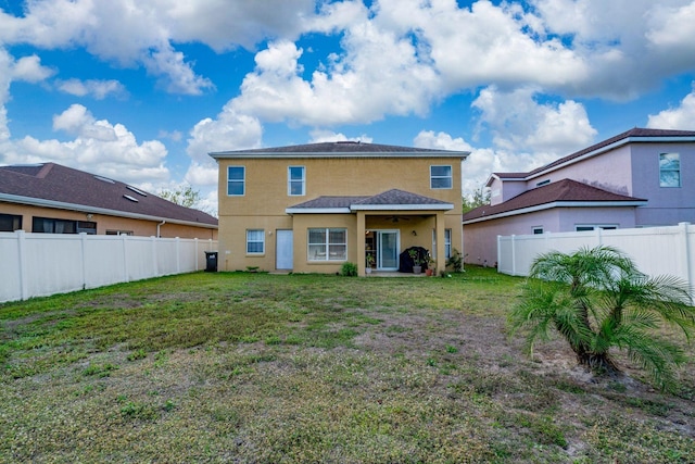 back of property with a lawn, a fenced backyard, and stucco siding