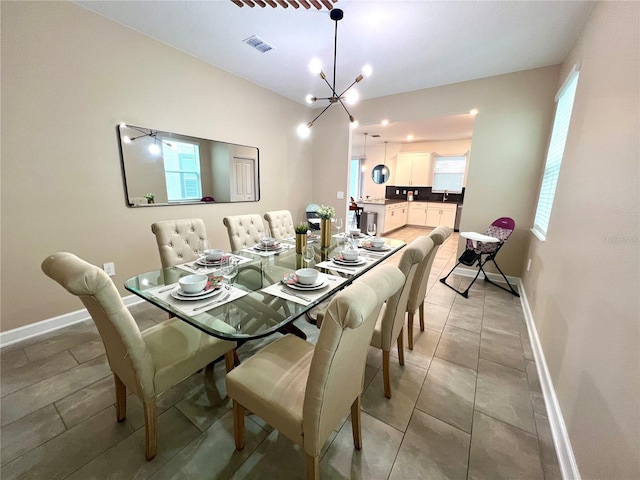 dining space featuring light tile patterned floors, visible vents, baseboards, and an inviting chandelier