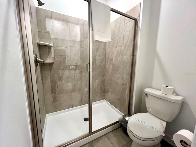 bathroom featuring toilet and a shower stall