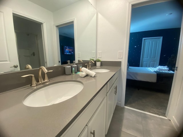 full bathroom featuring tile patterned flooring, double vanity, ensuite bathroom, and a sink