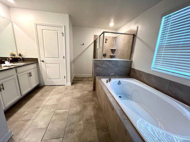 full bath featuring vanity, a shower stall, and a garden tub