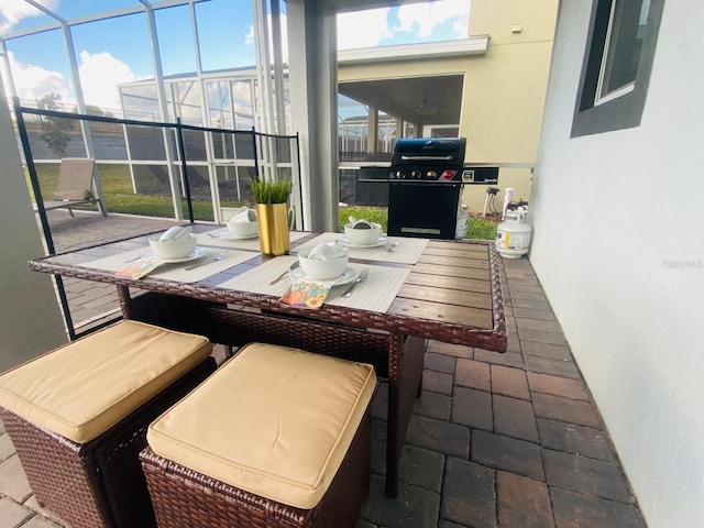 view of patio / terrace with grilling area and glass enclosure