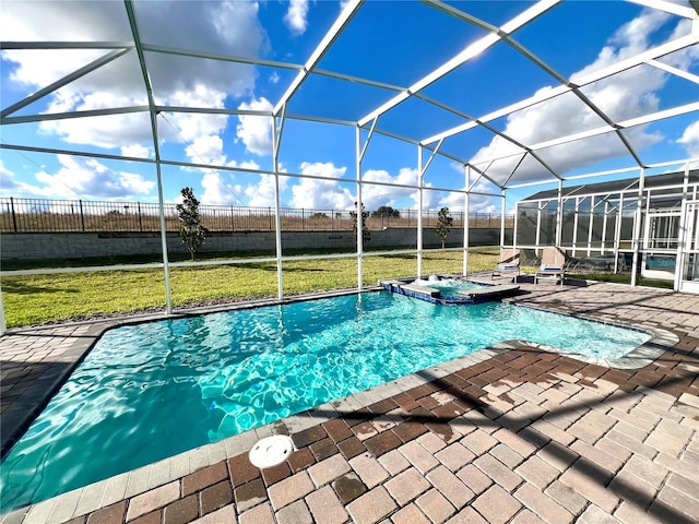 view of swimming pool with a lawn, a pool with connected hot tub, fence, a lanai, and a patio area