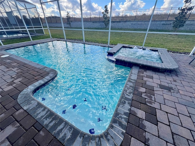 outdoor pool featuring a lanai, an in ground hot tub, a yard, and a patio