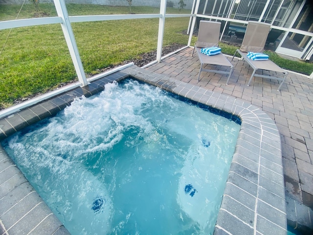 view of swimming pool with a lawn, an in ground hot tub, a lanai, and a patio area