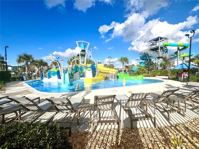 pool with a water slide and a water play area