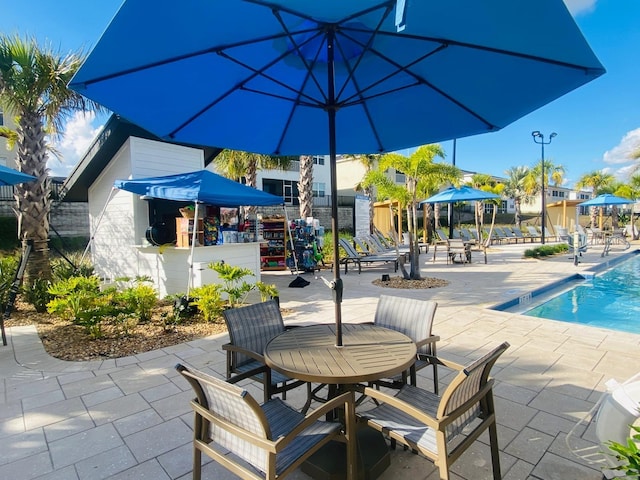 pool featuring outdoor dining area and a patio area