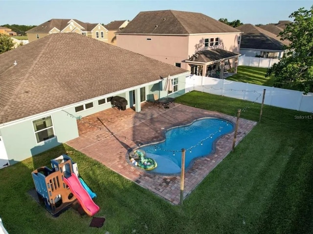 view of pool featuring a fenced backyard, a playground, a yard, a fenced in pool, and a patio area