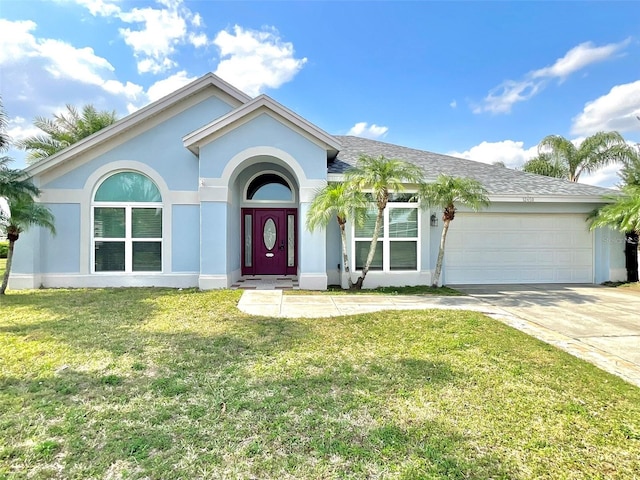 ranch-style home featuring a front yard, a shingled roof, stucco siding, concrete driveway, and a garage