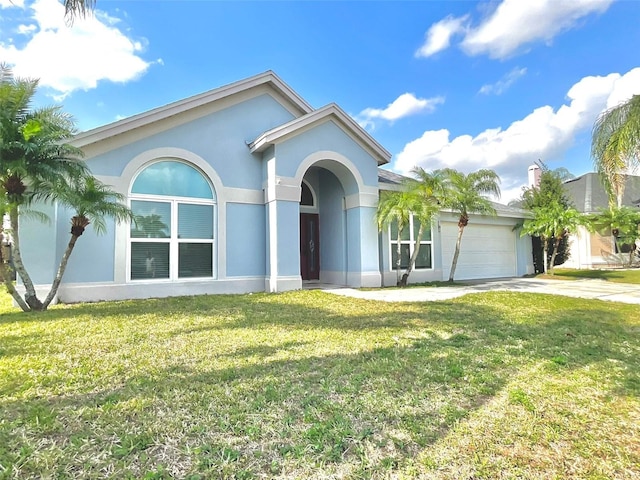 view of front of house with a front lawn, concrete driveway, an attached garage, and stucco siding