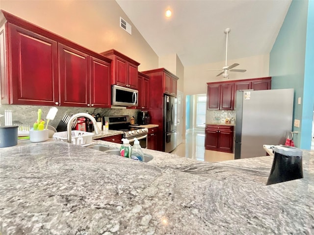 kitchen with visible vents, dark brown cabinets, ceiling fan, decorative backsplash, and stainless steel appliances