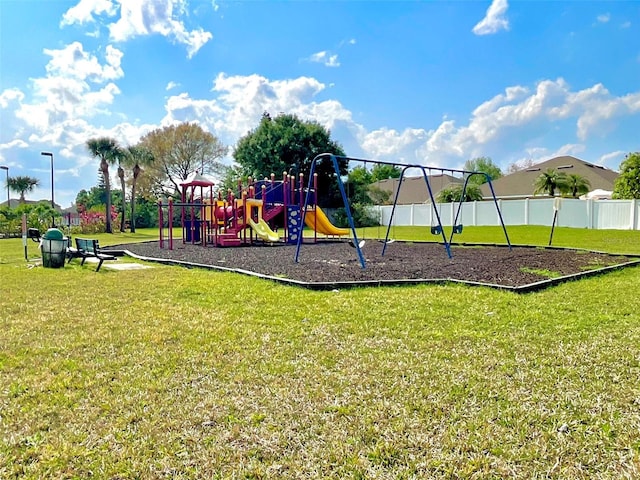 communal playground with a yard and fence