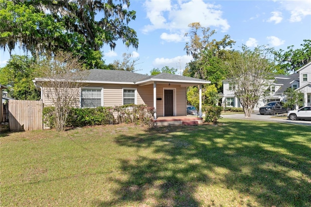 view of front facade with a front lawn and fence