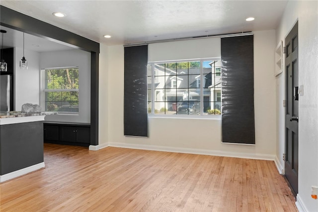 interior space with recessed lighting, wood finished floors, and baseboards