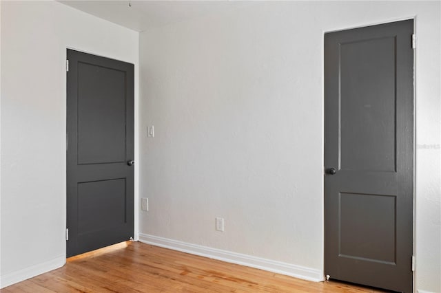 spare room featuring baseboards and light wood-style flooring