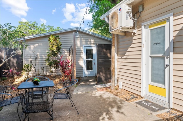 view of patio / terrace featuring an outbuilding, ac unit, and outdoor dining area