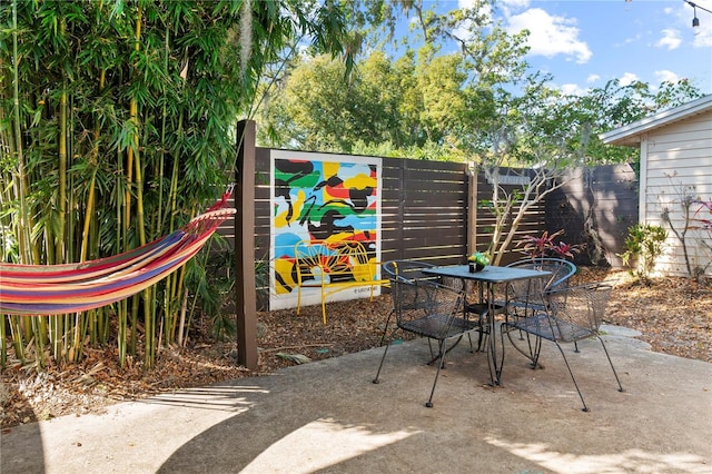 view of patio with outdoor dining area and fence