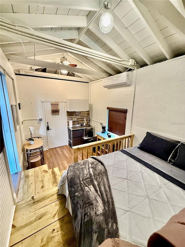 bedroom with a wall mounted air conditioner, lofted ceiling with beams, and wood finished floors