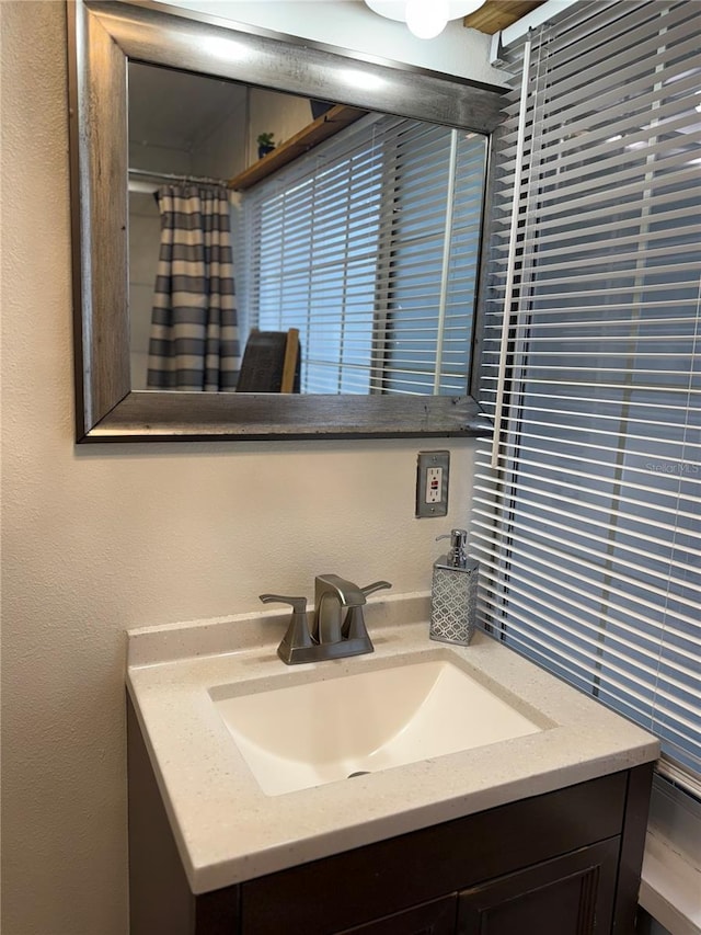 bathroom with vanity and a textured wall