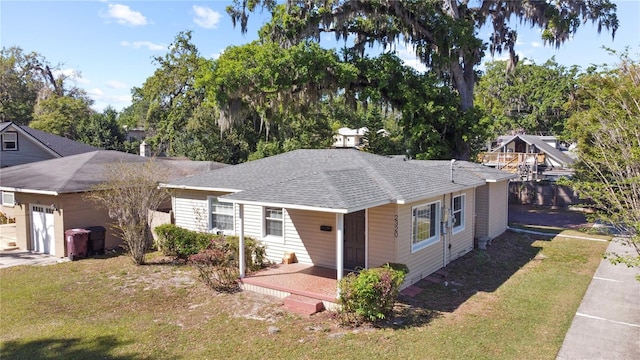 view of front of property with a front lawn and roof with shingles