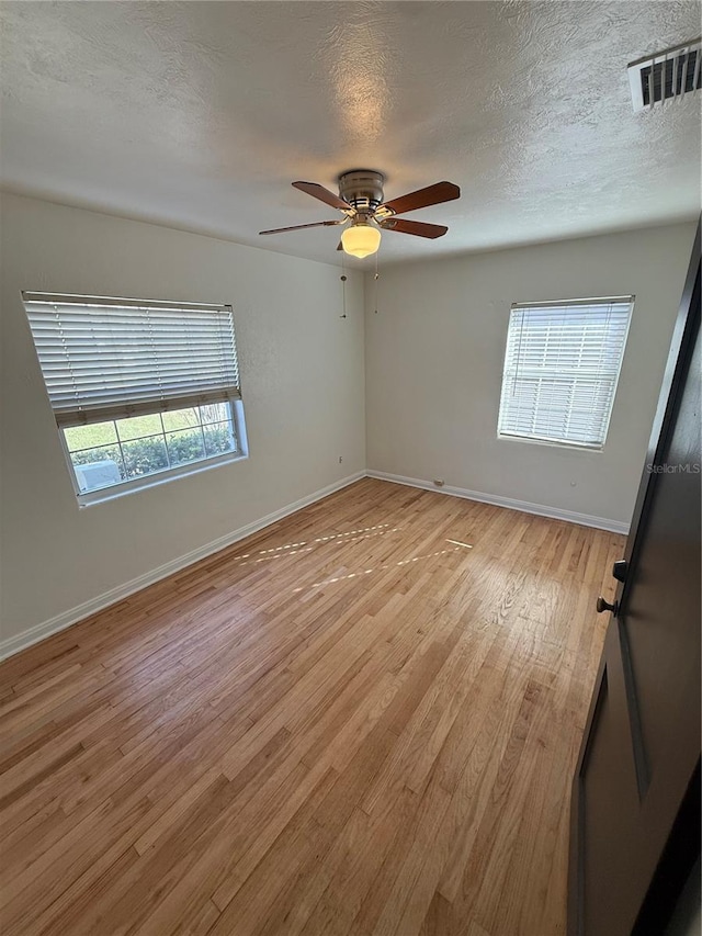 empty room with visible vents, baseboards, and light wood-style floors