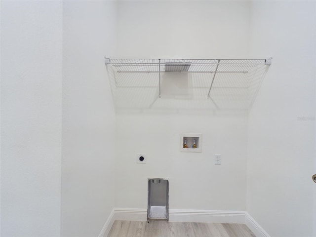 laundry area featuring baseboards, laundry area, hookup for a washing machine, light wood-style flooring, and electric dryer hookup