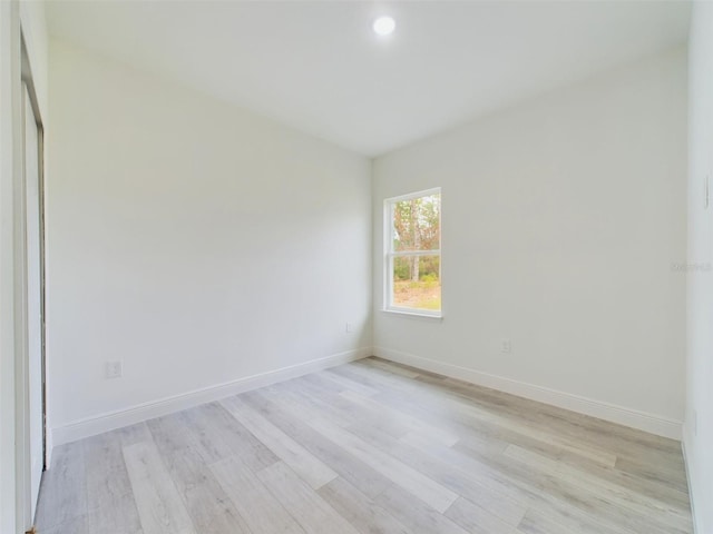 unfurnished room with baseboards and light wood-style flooring