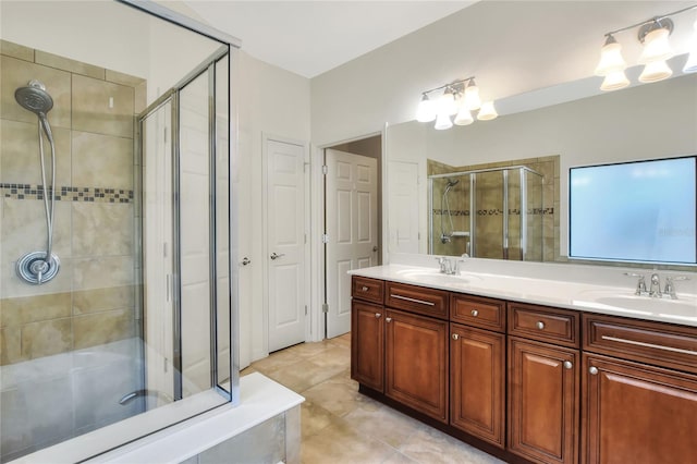 full bathroom featuring double vanity, a shower stall, tile patterned floors, and a sink